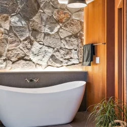 free standing tub back lit with rock wall