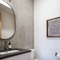 half bath remodel with rounded mirror above vanity